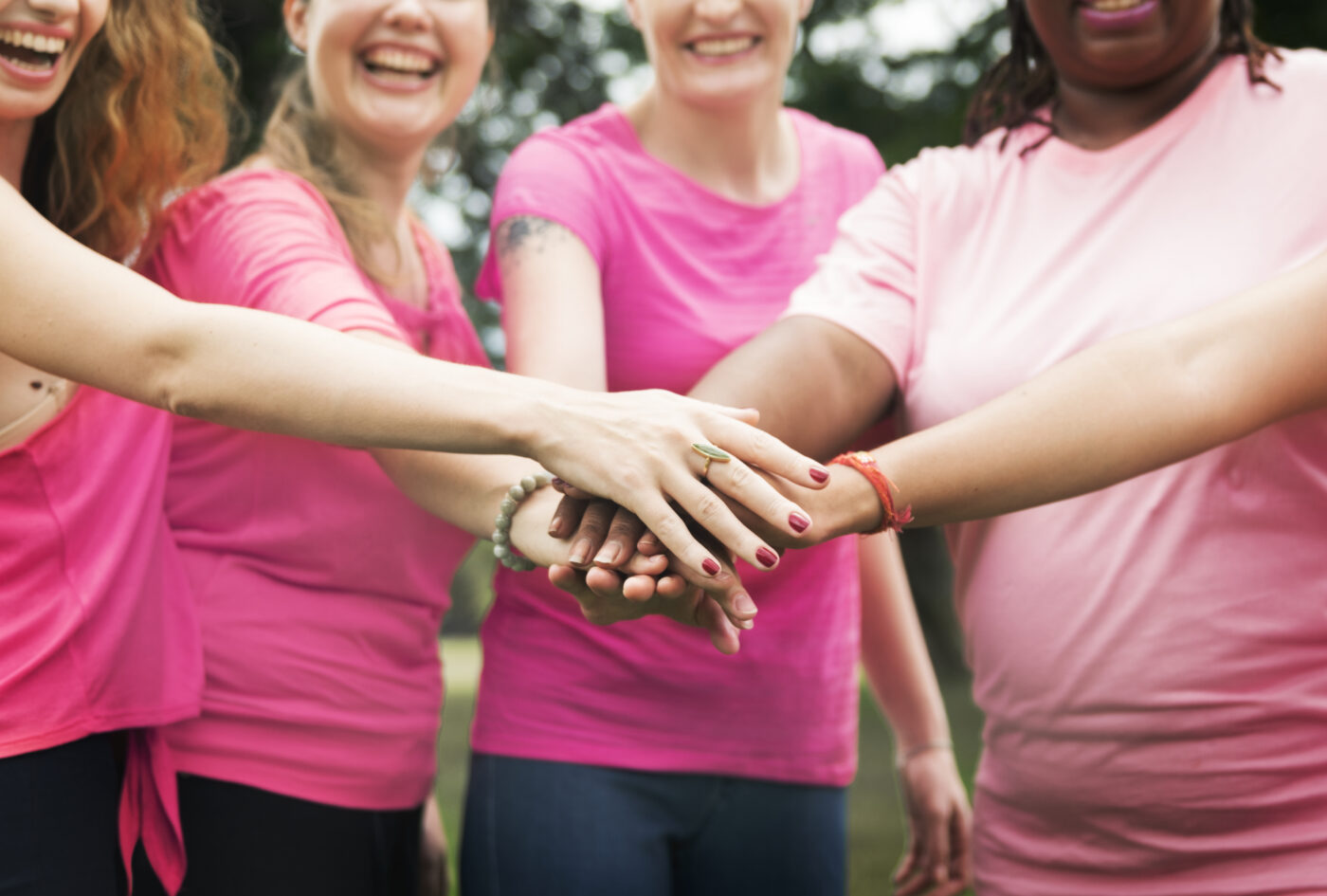 Octobre Rose au Cœur des Pyrénées : femmes vêtues de rose réunies leurs mains au centre d'un cercle